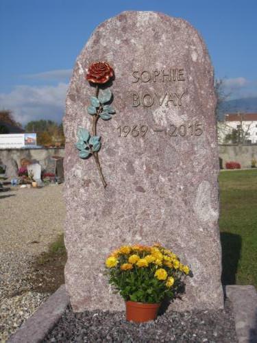 Monument funéraire en granit rouge avec rose et lettres en bronze